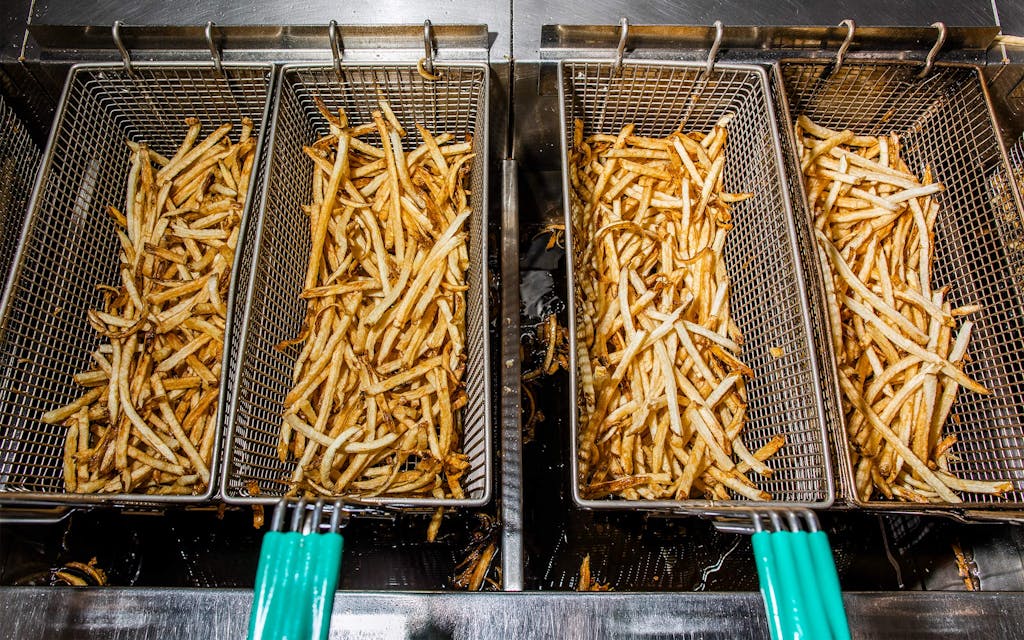 Batches of fries, fresh out of the oil.