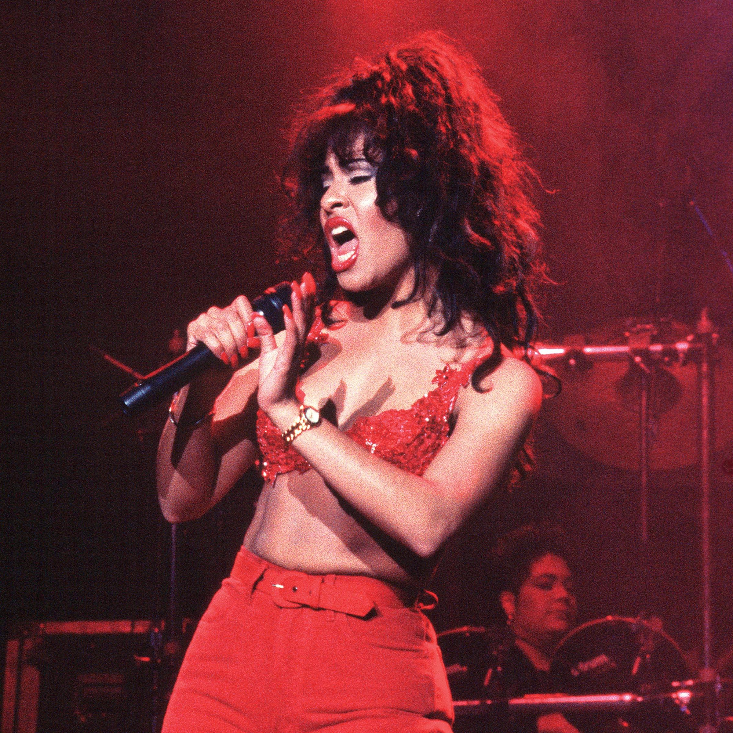 Selena, with a teased updo, performing in all red. 