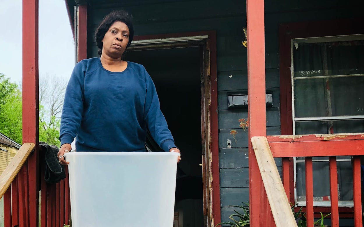 Shannon Sublette uses a plastic bin to collect water beneath her home.