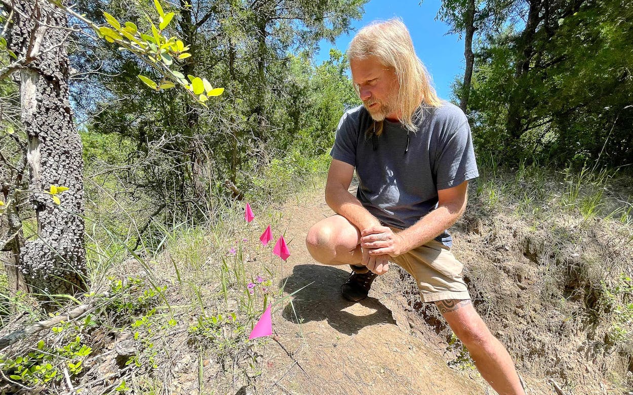 Adam Black checks a small and precariously located colony of Oklahoma grass pinks he has marked with stakes.