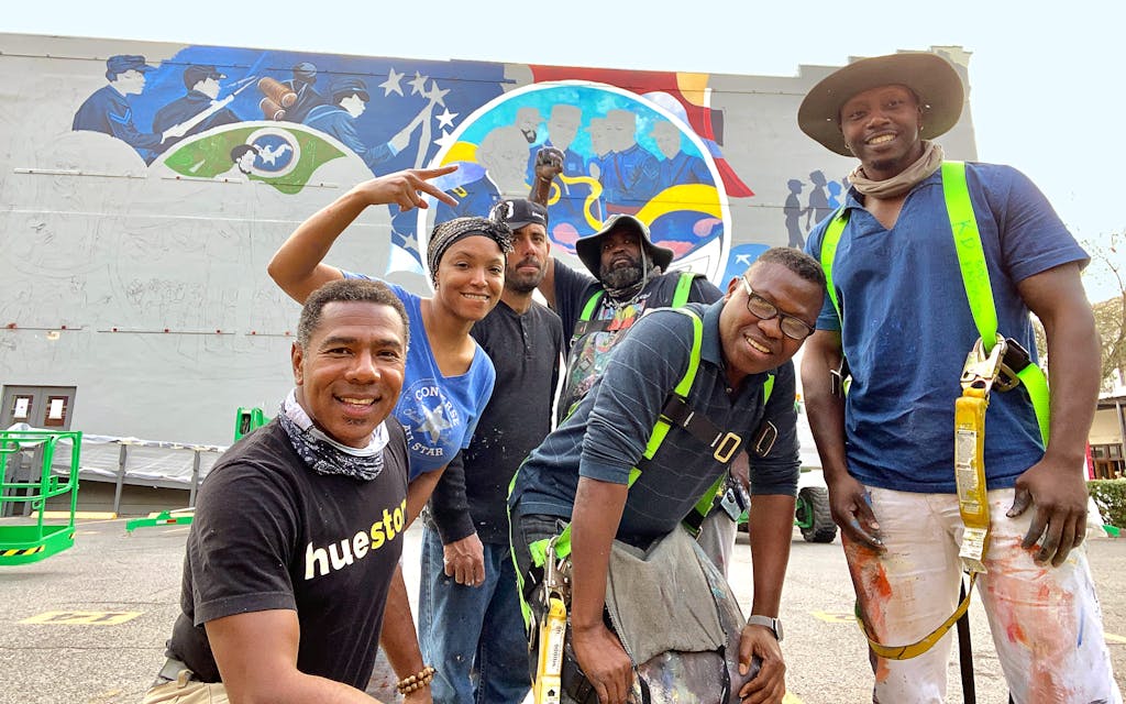 Reginald Adams and his team of artists pose in front of their unfinished mural. 