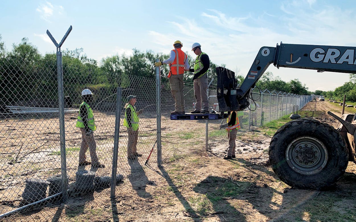 Texas National Guardsmen add razor wire to the top of the fence, just west of Del Rio on July 21, 2021.
