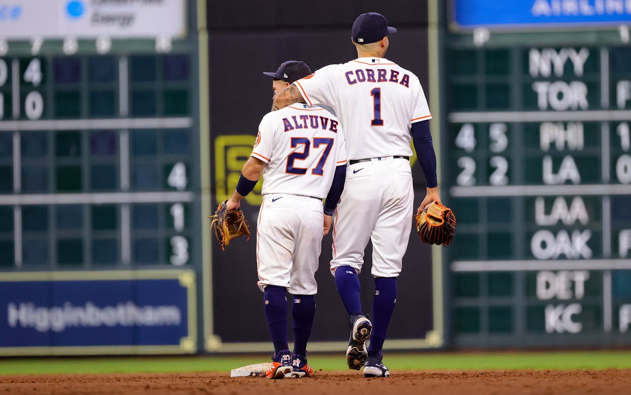 Jose Altuve #27 and Carlos Correa #1 of the Houston Astros in action against the Texas Rangers at Minute Maid Park on June 16, 2021 in Houston, Texas.
