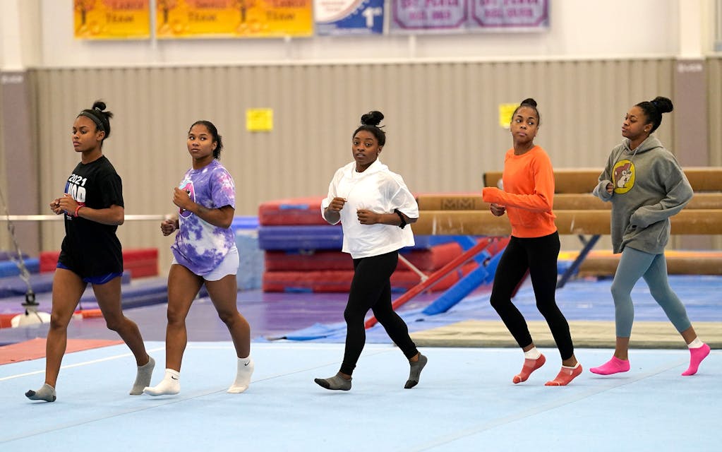 La gymnaste championne olympique en titre Simone Biles, au centre, s'entraîne avec d'autres gymnastes le mardi 11 mai 2021, à Spring, Texas.