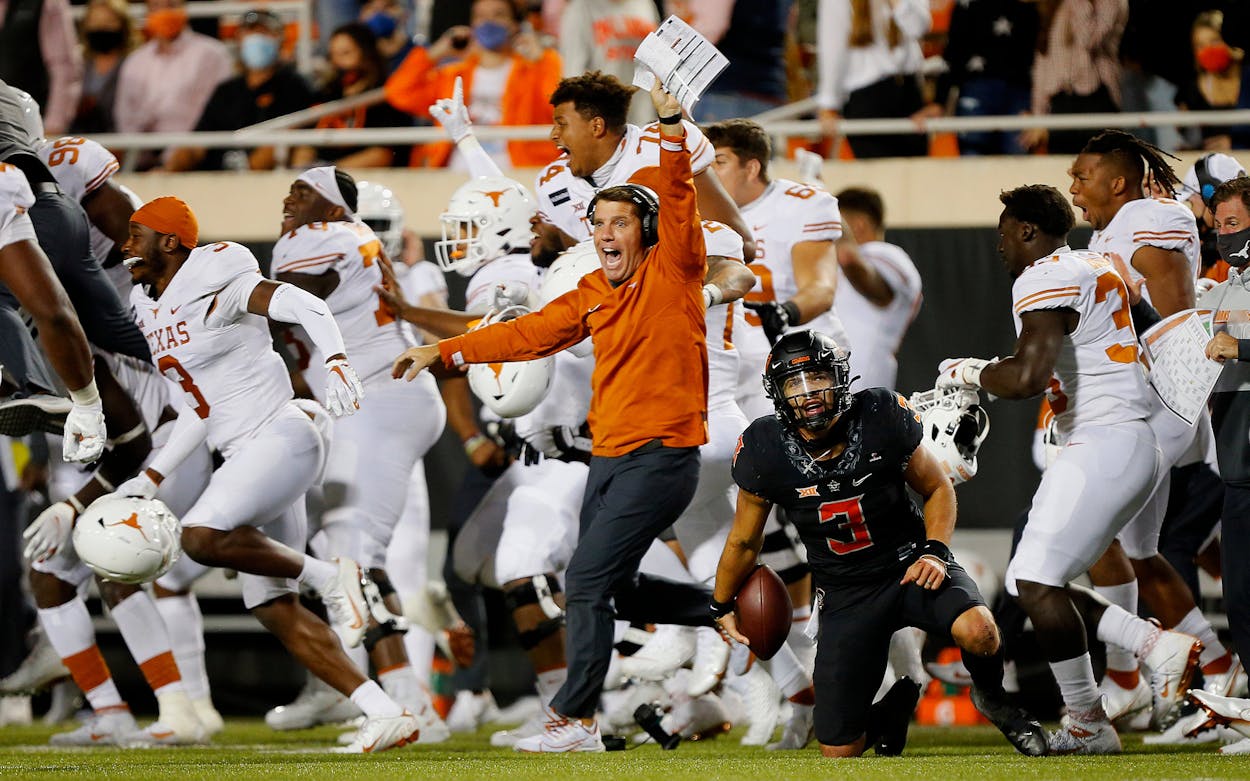 The Texas Longhorns celebrate their upset victory as quarterback Spencer Sanders #3 of the Oklahoma State Cowboys reacts after getting taken down on the final play in overtime against the Texas Longhorns on October 31, 2020.