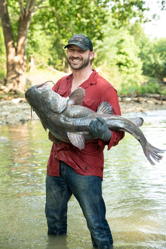 Will Roman holding a catfish he caught noodling.