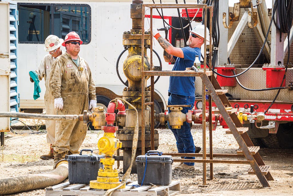Jeff Fine (left) and Dustin Frazier prep a Quidnet Energy well for a test that involves injecting water into the rock formation below, outside of Hondo, on August 3, 2021.