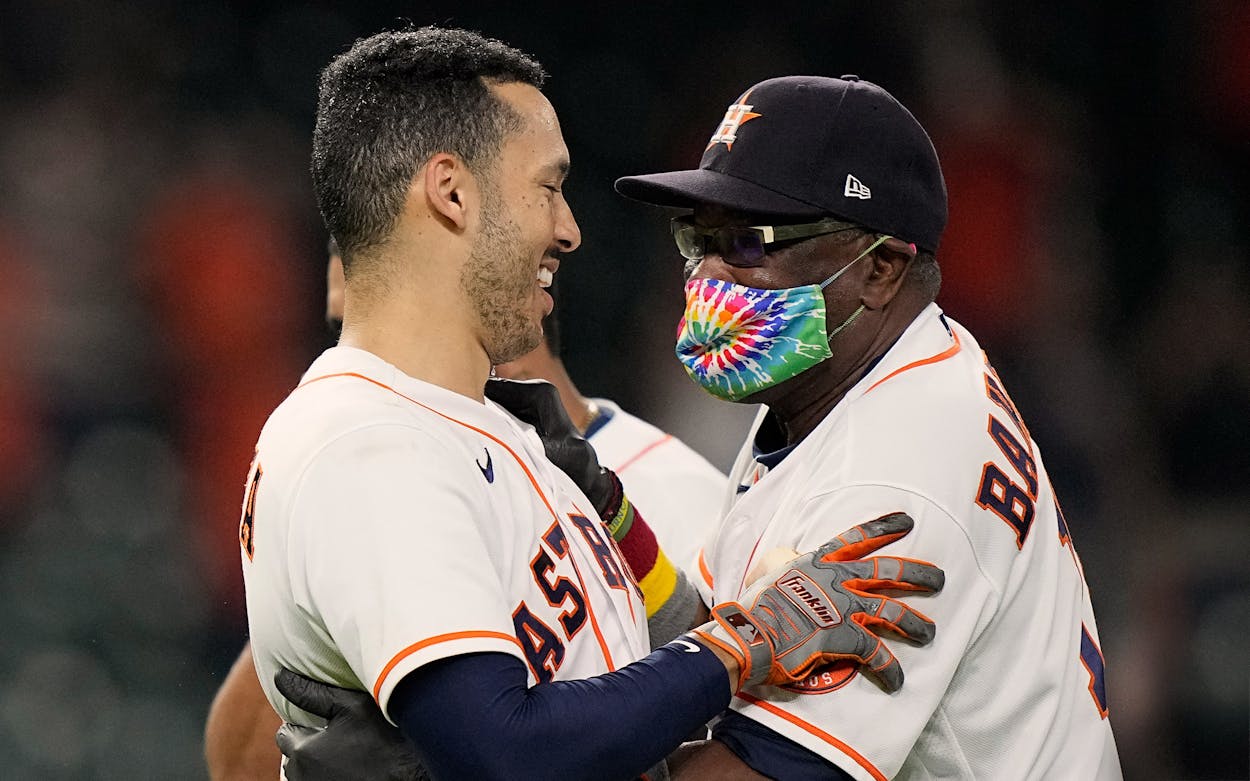 Houston Astros' Carlos Correa, left, celebrates with manager Dusty Baker Jr. after hitting a game-winning RBI ground-rule double against the Seattle Mariners during the 10th inning of a baseball game Tuesday, Sept. 7, 2021, in Houston.