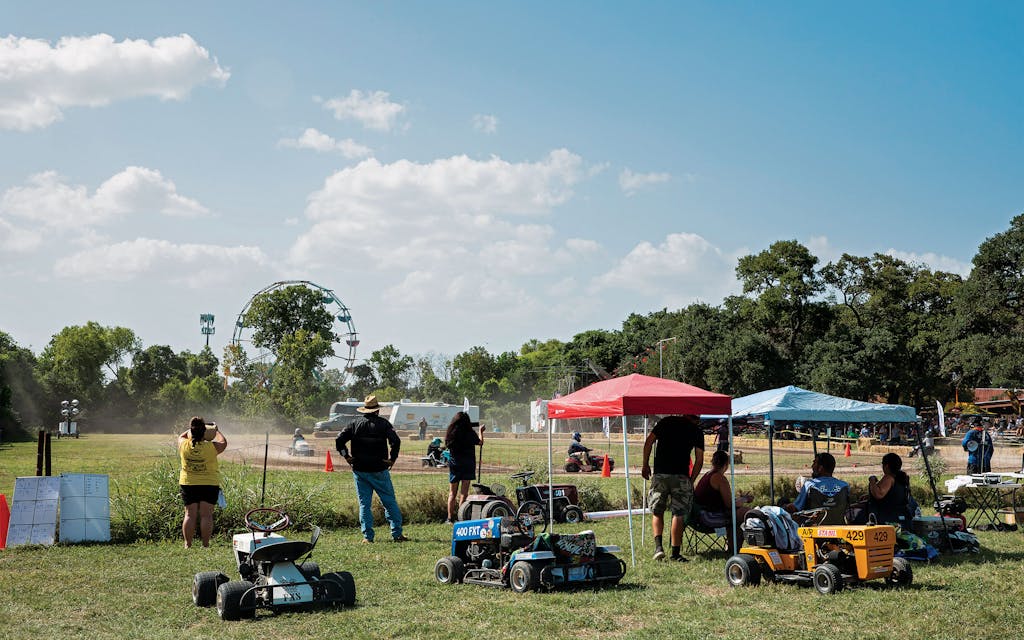 Competitors watch from the sidelines at the Lone Star Mower Racing Association lawn mower races at the Kendall County Fairgrounds in Boerne, on September 4, 2021.