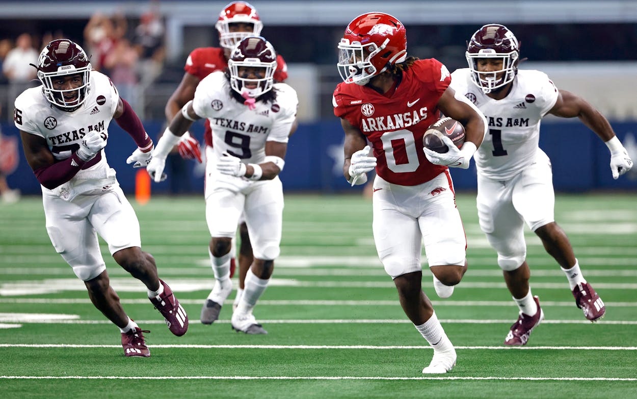 AJ Green #0 of the Arkansas Razorbacks runs past a host of Texas A&M Aggies defenders before scoring a touchdown in the first half of the Southwest Classic at AT&T Stadium on September 25, 2021 in Arlington, Texas.