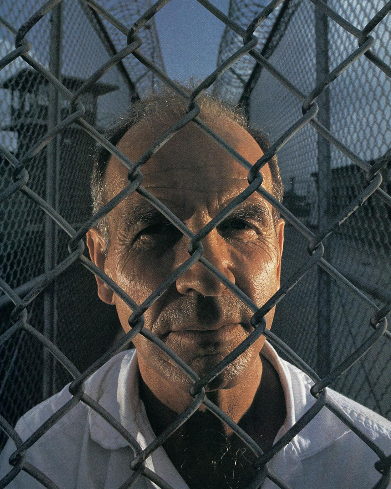 Howard Pharr looks through a chain link fence at prison.