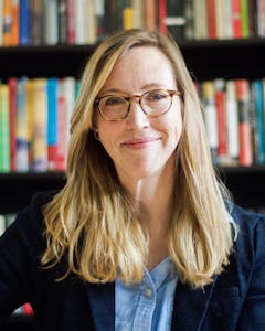 Headshot of Dr. Caitlin M. Casey smiling in front of a bookcase.