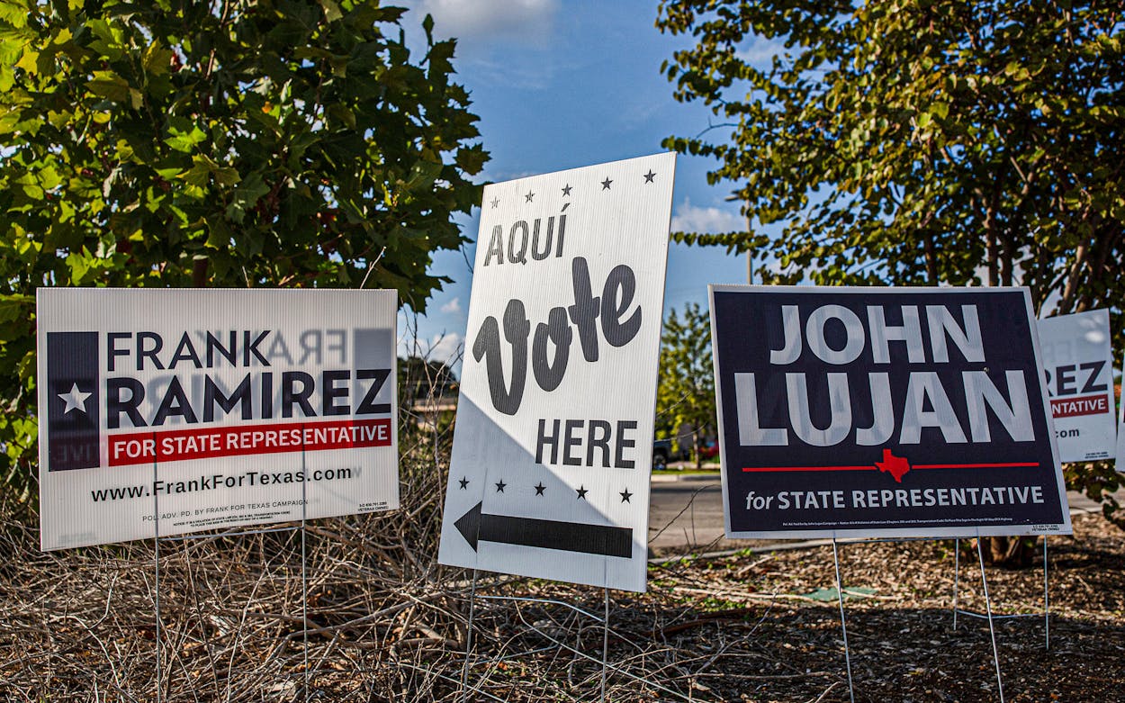 Campaign signs for Republican John Lujan and Democrat Frank Ramirez, who are running for the Texas House District 118 seat, are displayed near a polling place in San Antonio on October 21, 2021.