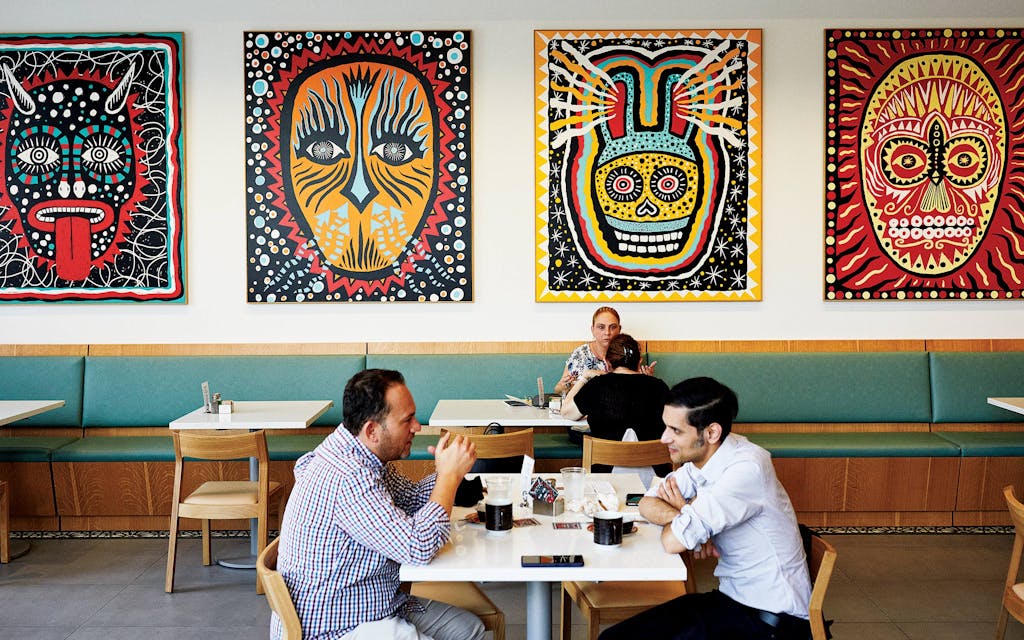 Diners sitting amid art by the Houston printmaker Carlos Hernandez.