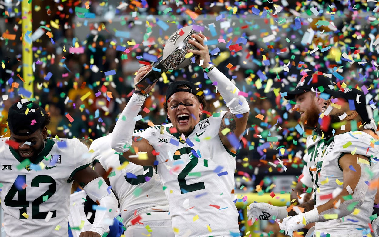 Terrel Bernard #2 of the Baylor Bears holds the Big 12 Championship trophy and celebrates with teammates after Baylor defeated the Oklahoma State Cowboys 21-16 in the Big 12 Football Championship at AT&T Stadium on December 4, 2021 in Arlington, Texas.