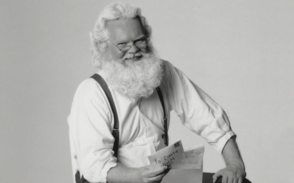 Black and white photo of a smiling Santa Claus in 1990. 