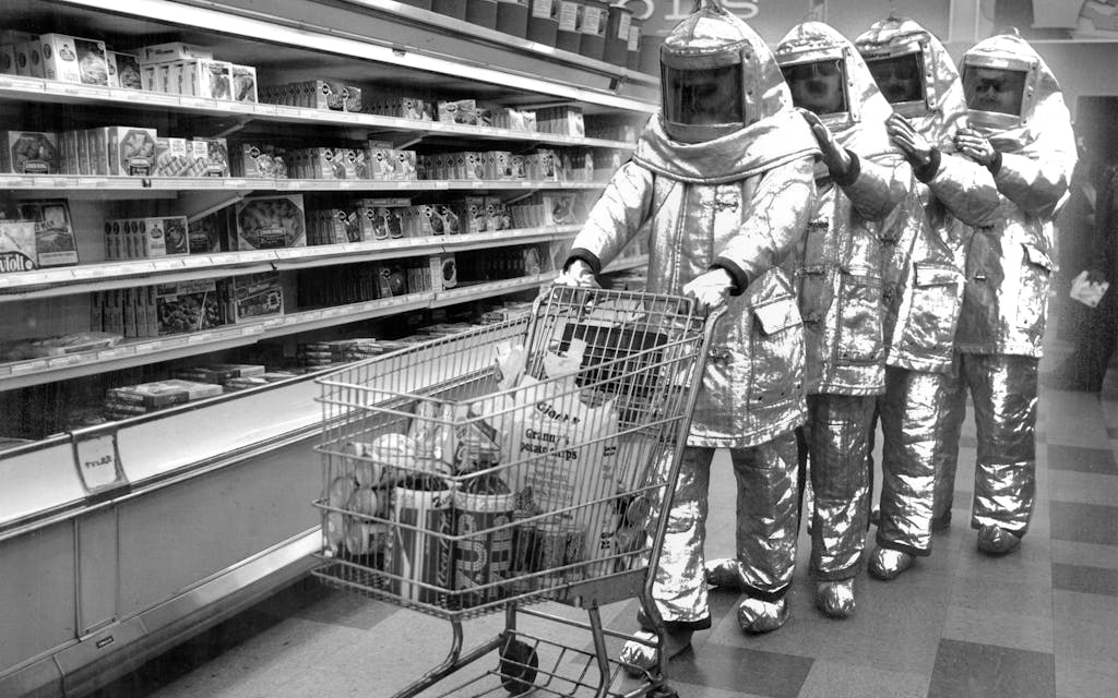 The Residents circa 1978 in a promotional photo showing them wearing space suits while shopping in a grocery store.