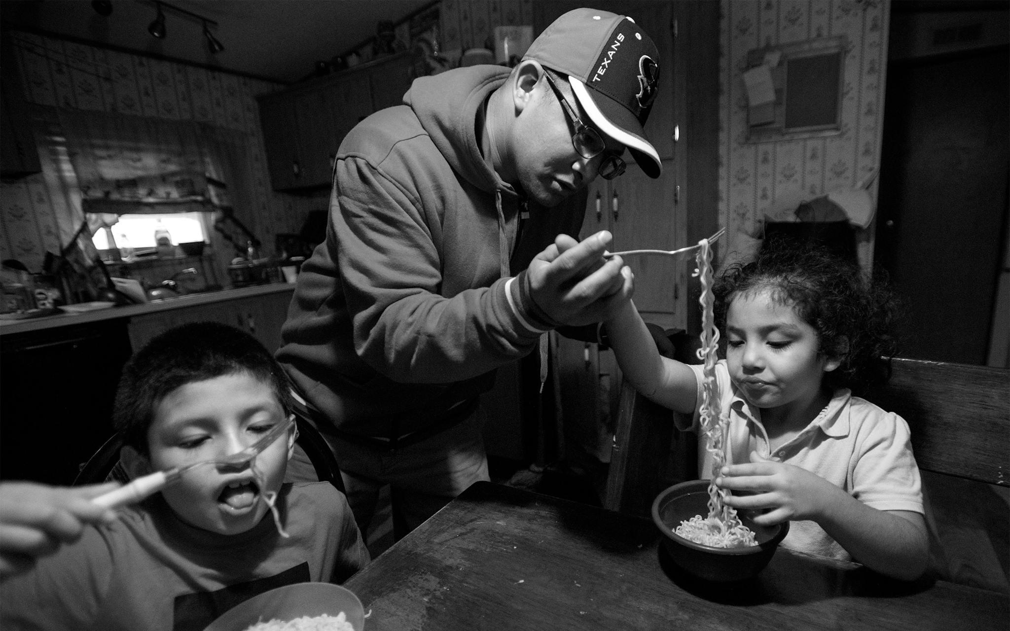 Lee Martinez serves ramen noodles to his sister Arleen’s children, Diomani and Hailee Rivera, at the home they shared with Lee’s mother Maricela in Kyle, after picking them up from school on November 7, 2019.