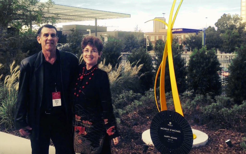 Michelle O'Michael and Steve Archer pose next to one of their metal sculptures.