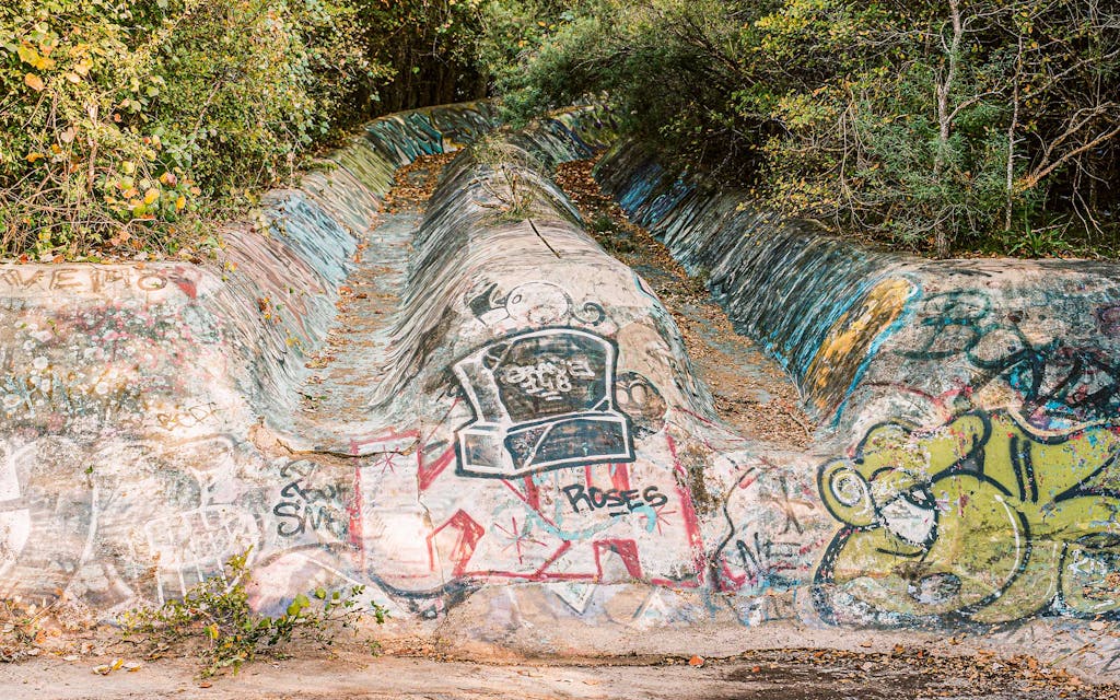 The now-defunct Aqua Thrill Way water slide in Austin is overgrown and covered in graffiti.