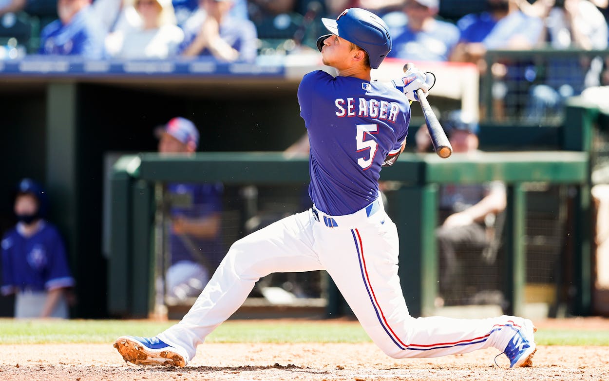Corey Seager #5 of the Texas Rangers hits a sacrifice fly during the second inning of the MLB spring training game against the Los Angeles Dodgers on March 31, 2022 in Surprise, Arizona.