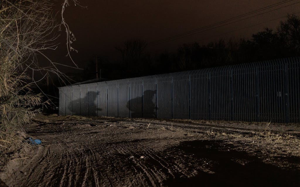 The shadows of members of the Patriots for America Militia are visible on the border wall in Eagle Pass on January 27, 2022.