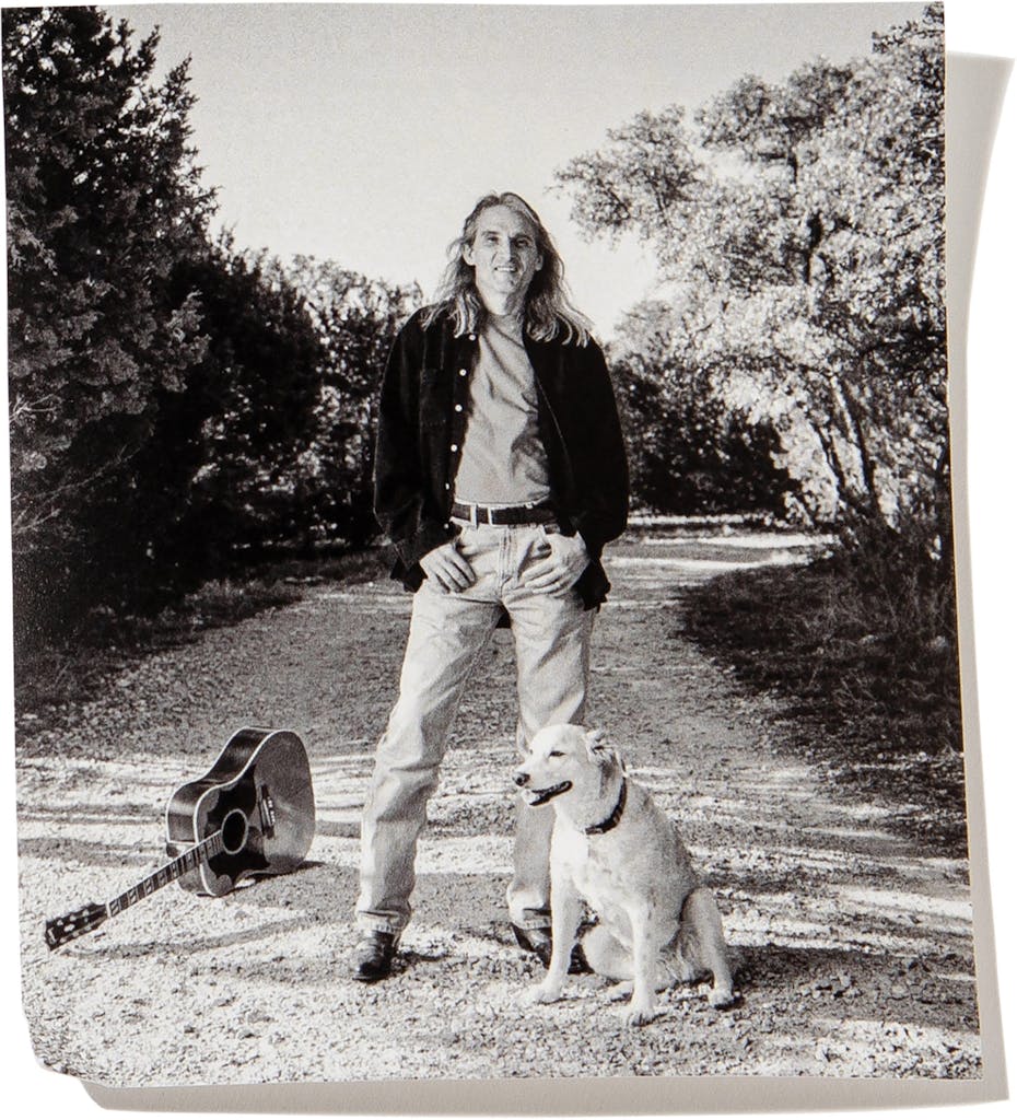 Jimmie Dale Gilmore with his dog Lira in the driveway of his home, outside Austin, in 2000.