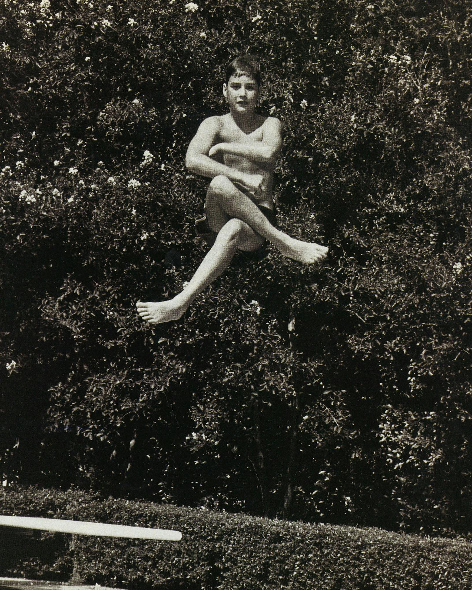 Luke Wilson jumping into a pool in midair.