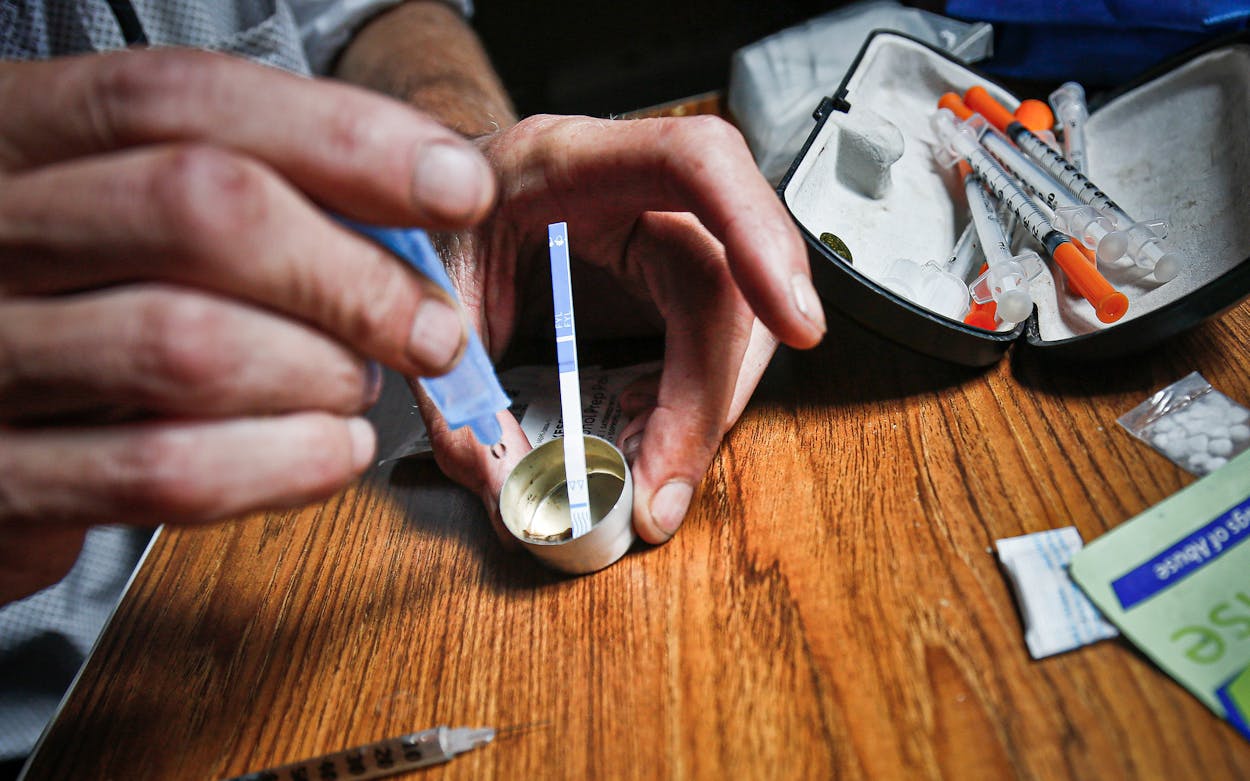 A heroin user tests for contamination with a fentanyl testing strip.