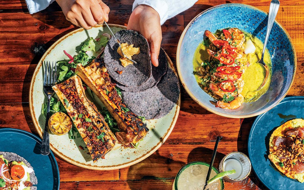 One of the specialties at Chivos in Houston is marrow bones covered in an earthy crust of sesame seeds and morita, ancho, and pasilla chiles on a bed of greens and pickled radishes with a side of grill-toasted tortillas.