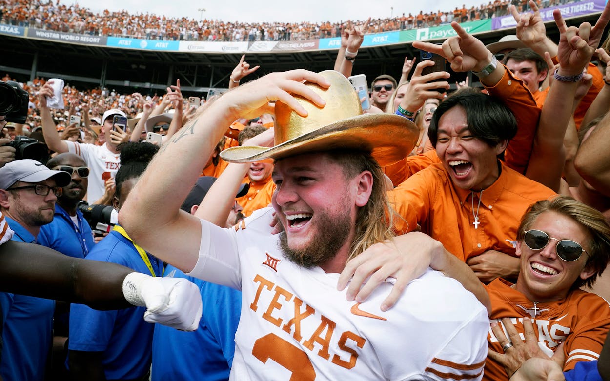 Texas quarterback Quinn Ewers celebrates by donning the golden hat with fans after winning an NCAA college football game against Oklahoma 49-0 at the Cotton Bowl in Dallas, Saturday, Oct. 8, 2022.