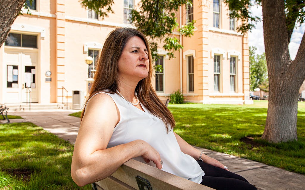 Democrat Dina Jo Losoya Marquez, Justice of the Peace Precinct 1 for Presidio County, sits on a bench overlooking the county courthouse lawn in Marfa.