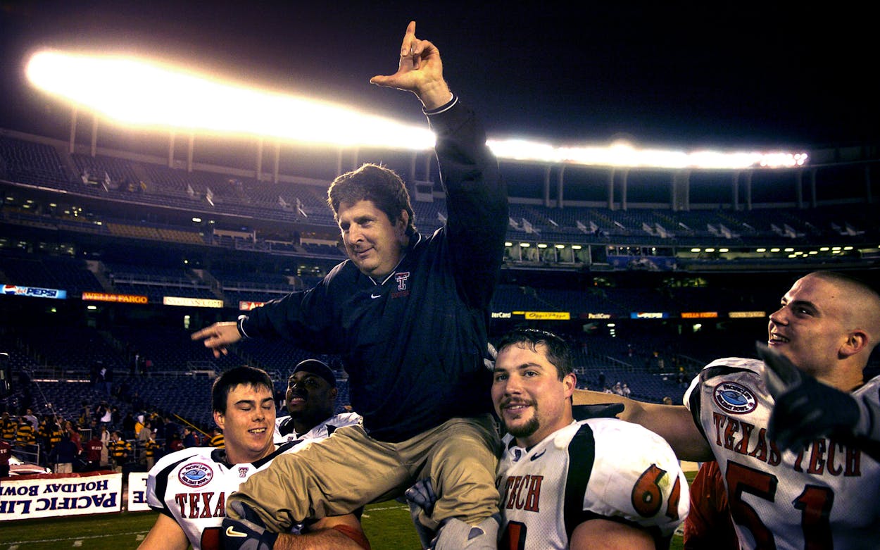 A celebratory Texas Tech coach Mike Leach is hoisted by Mike Smith (left) and Cody Campbell as Dek Bake (51) watches after 45-31 victory over Cal in the Pacific Life Holiday Bowl at Qualcomm Stadium in San Diego, Calif. on Thursday, Dec. 30, 2004.