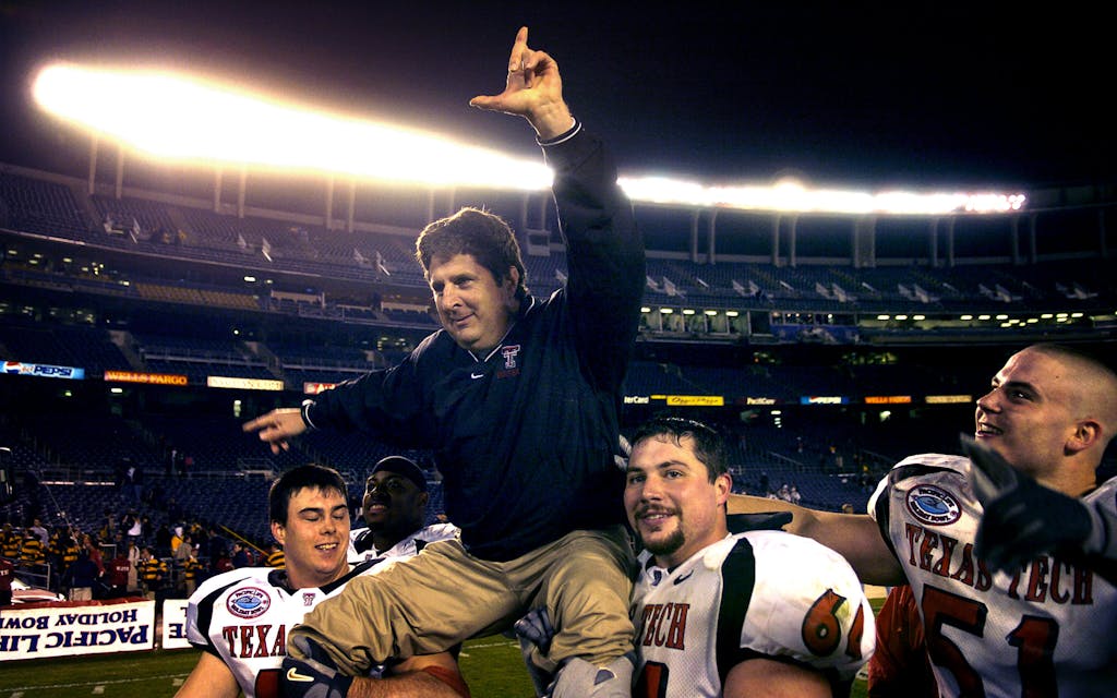 A celebratory Texas Tech coach Mike Leach is hoisted by Mike Smith (left) and Cody Campbell as Dek Bake (51) watches after 45-31 victory over Cal in the Pacific Life Holiday Bowl at Qualcomm Stadium in San Diego, Calif. on Thursday, Dec. 30, 2004.