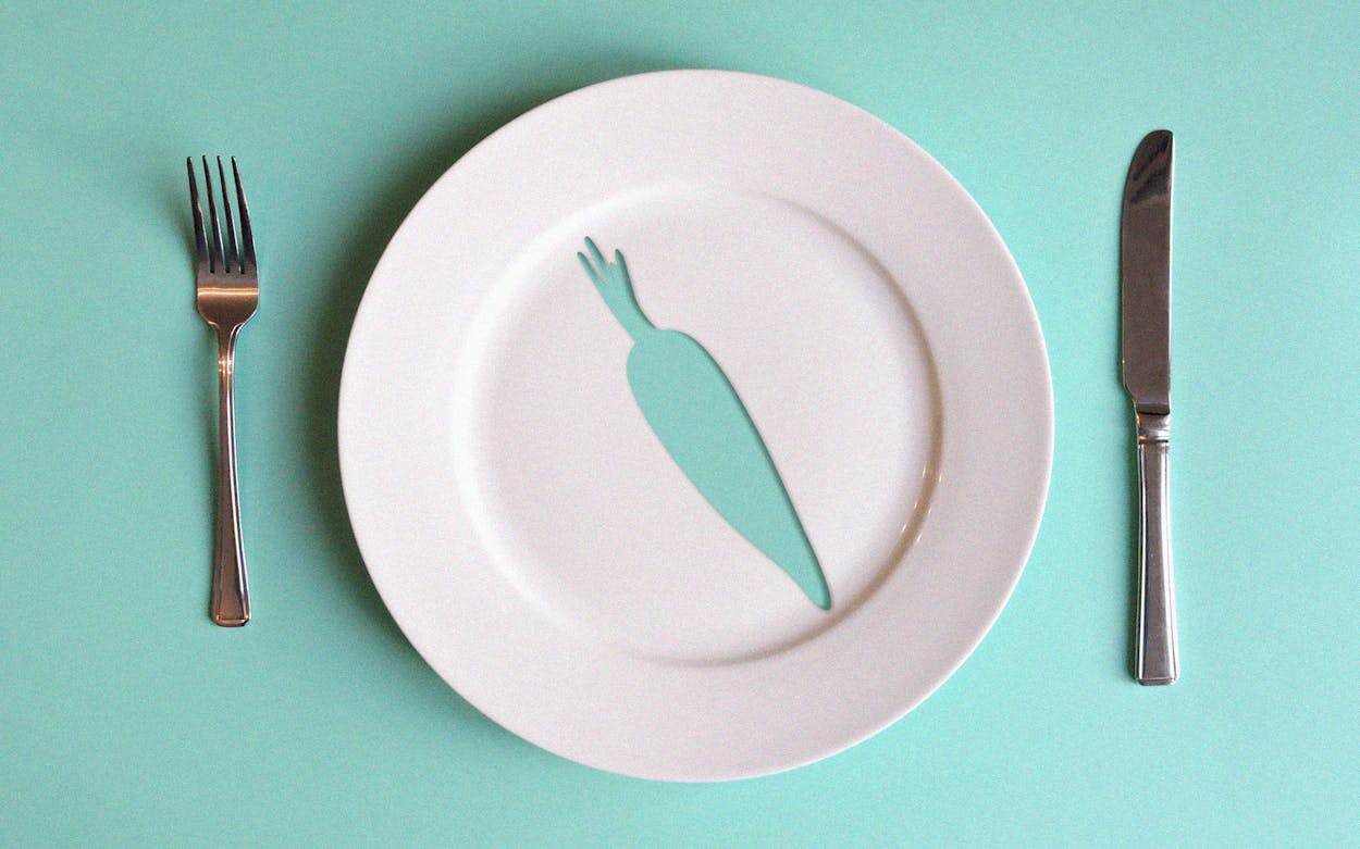 a white dinner plate with a cutout in the shape of a carrot.