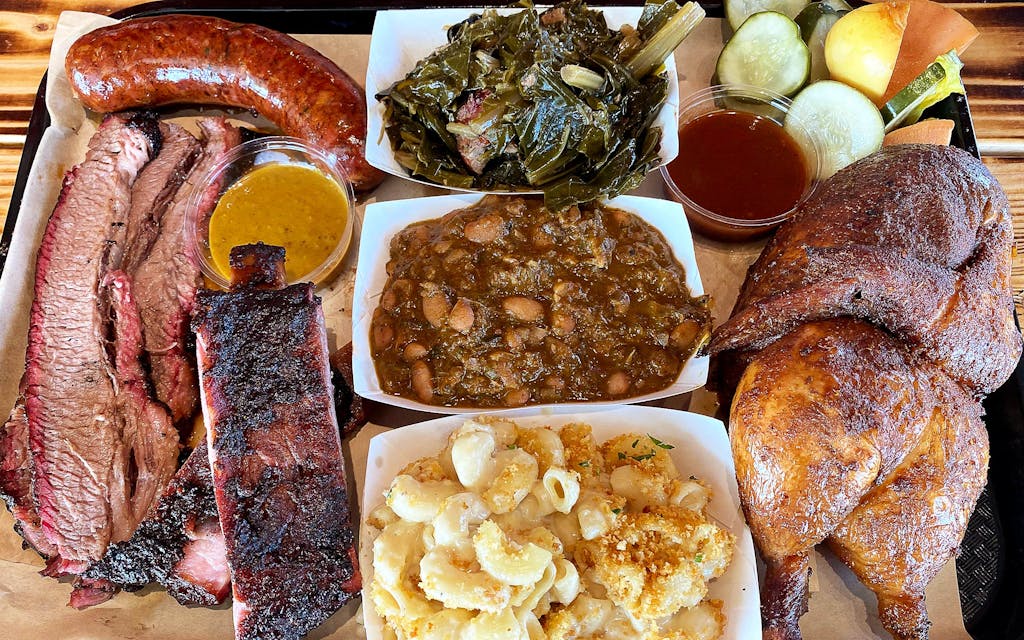 A spread of pork ribs, sausage, chicken, and sides. 