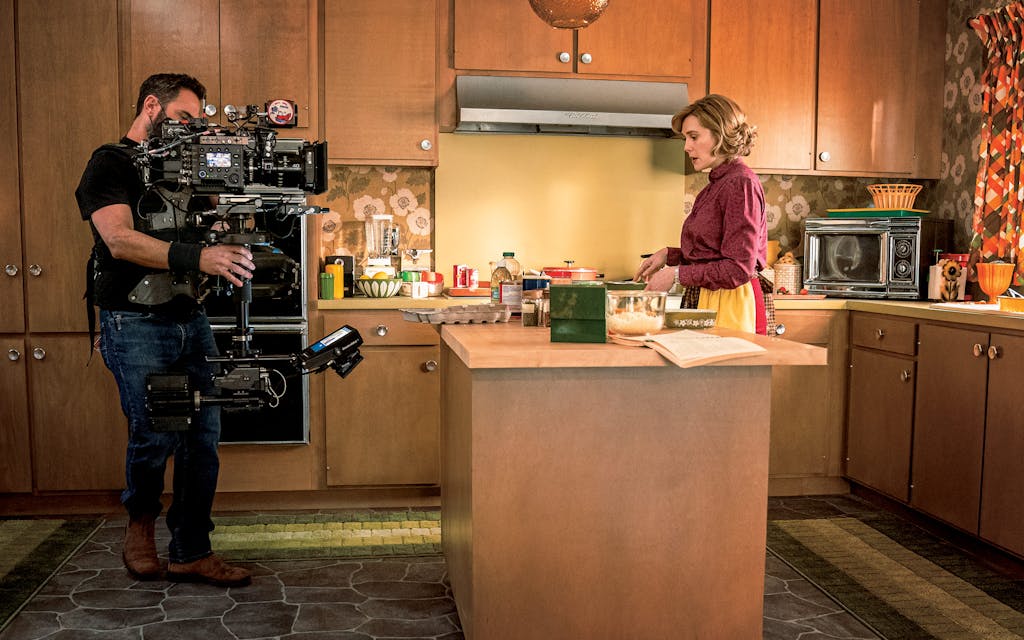 A cameraman filming Olsen on a soundstage replica of the author’s kitchen.