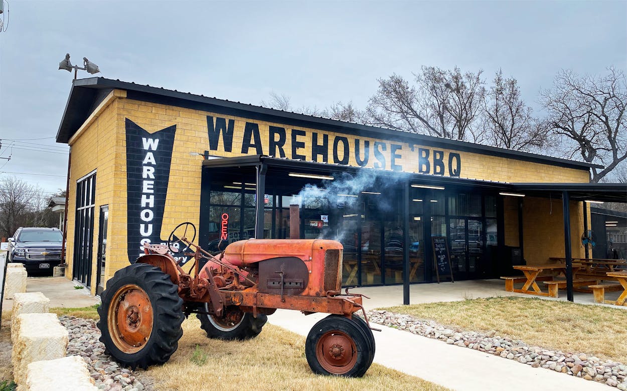 Smoking tractor in front of Warehouse BBQ and Meetery in Burnet