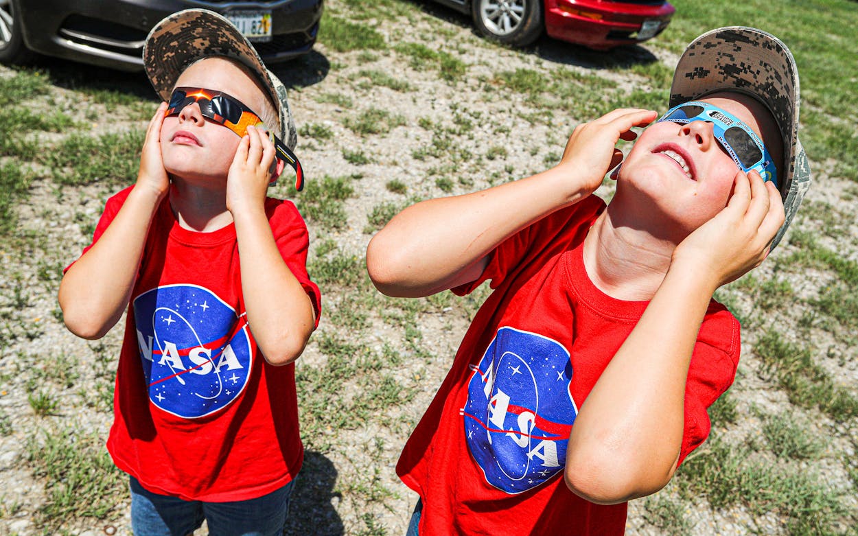 Two boys watch a solar eclipse on August 21, 2017, in Fort Worth.