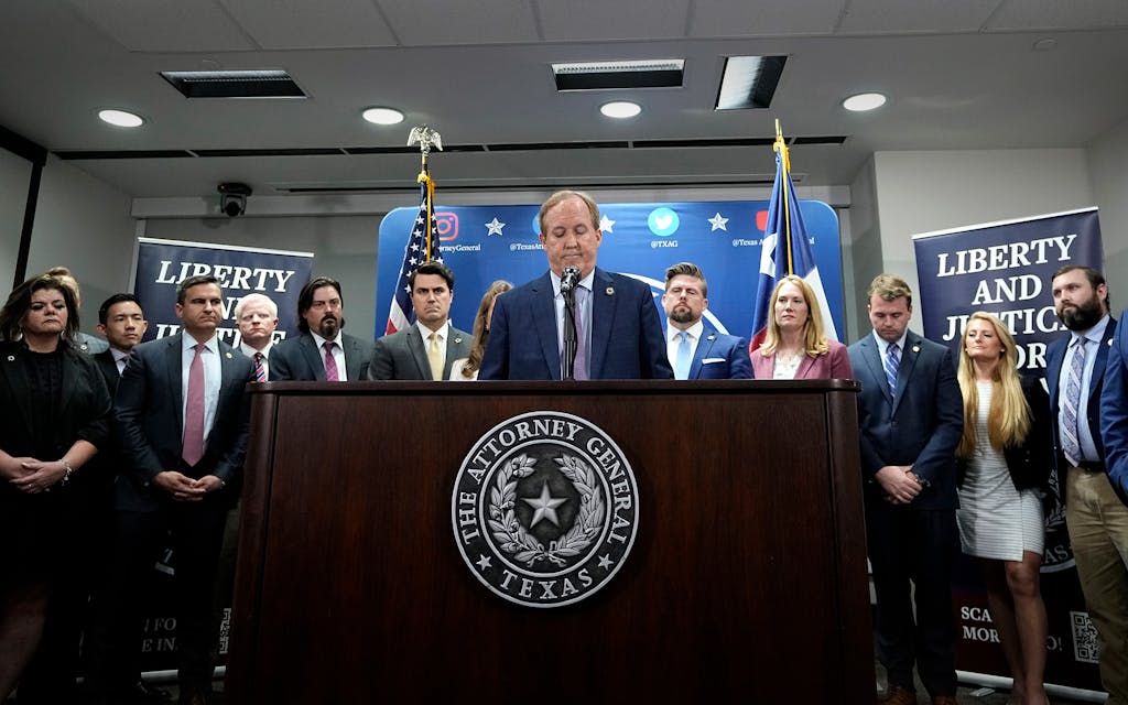 Texas state Attorney General Ken Paxton, center, flanked by his staff, reads a statement at his office in Austin, Texas, Friday, May 26, 2023. An investigating committee says the Texas House of Representatives will vote Saturday on whether to impeach state Attorney General Ken Paxton.