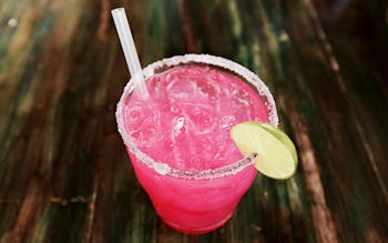A pink margarita with a lime round garnish