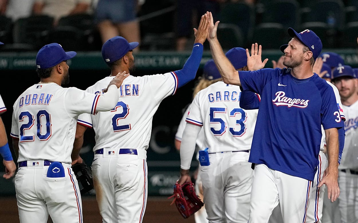 Texas Rangers' Ezequiel Duran (20), Marcus Semien (2) Max Scherzer, right, celebrate with the rest of the team after their 2-0 win inning of a baseball game against the Chicago White Sox, Tuesday, Aug. 1, 2023, in Arlington, Texas.