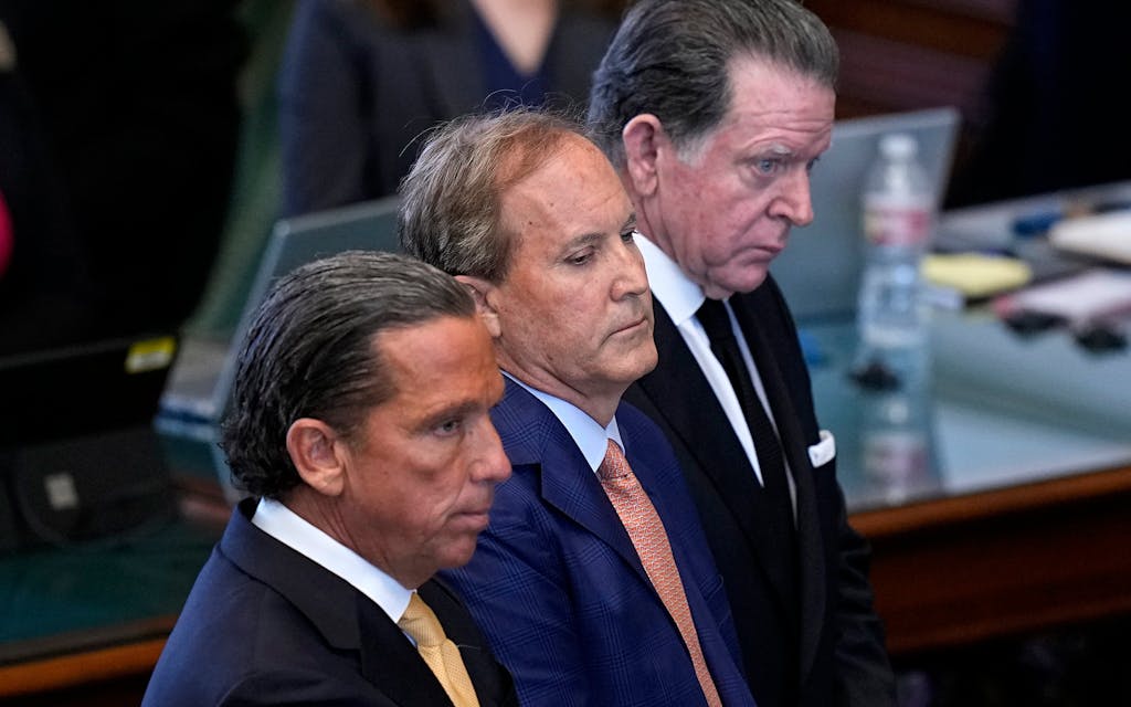 Texas state Attorney General Ken Paxton, center, stands between his attorneys Tony Buzbee, front, and Dan Cogdell, rear, as the articles of his impeachment are read during the his impeachment trial
