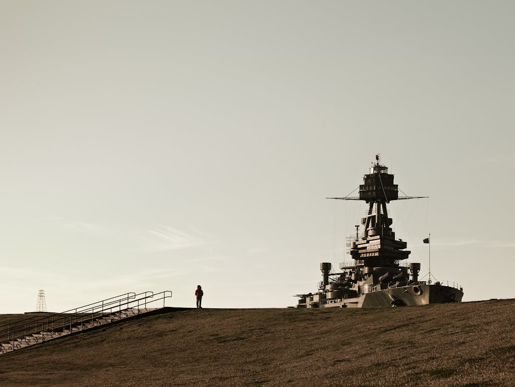 A visitor observing the U.S.S. Texas at the San Jacinto Monument in 2010 from atop one of the berms built to protect the historic site from tidal surges in Buffalo Bayou.