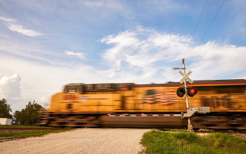 A train passes parallel to FM 2154 in Millican.