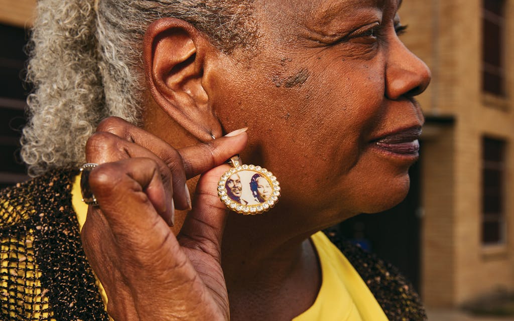 Nancy Harris displaying an earring with a photo of her parents.