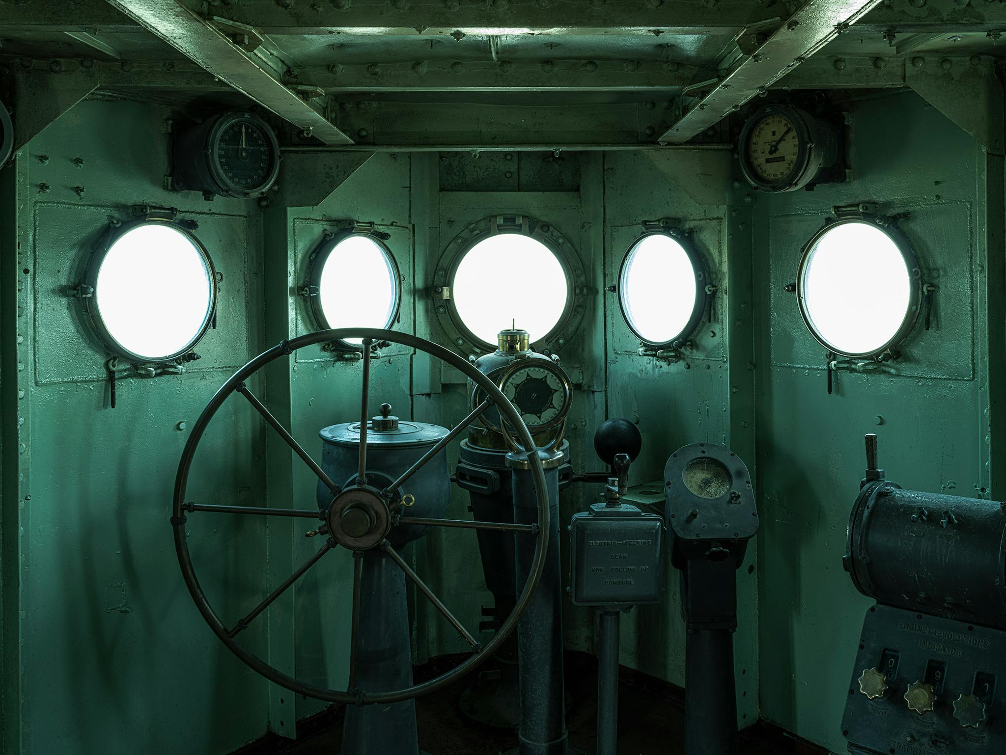 The pilot house, or bridge, where the helmsman turned the steering wheel (a.k.a. the helm) at the direction of the conning officer, who got his orders from the officer on the deck. To the right is the engine-order telegraph, on which orders were signaled to the engine room.