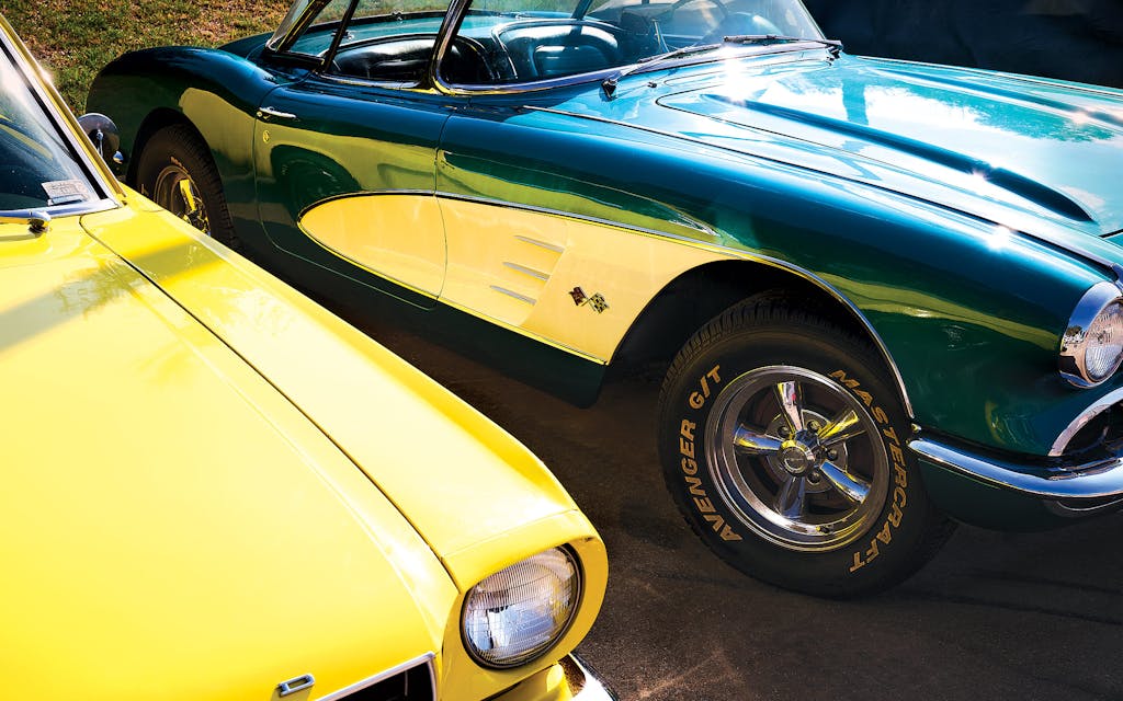 A yellow 1965 Ford Mustang Fastback and a turquoise 1959 Chevrolet Corvette, waiting to be converted at E-Muscle Cars.