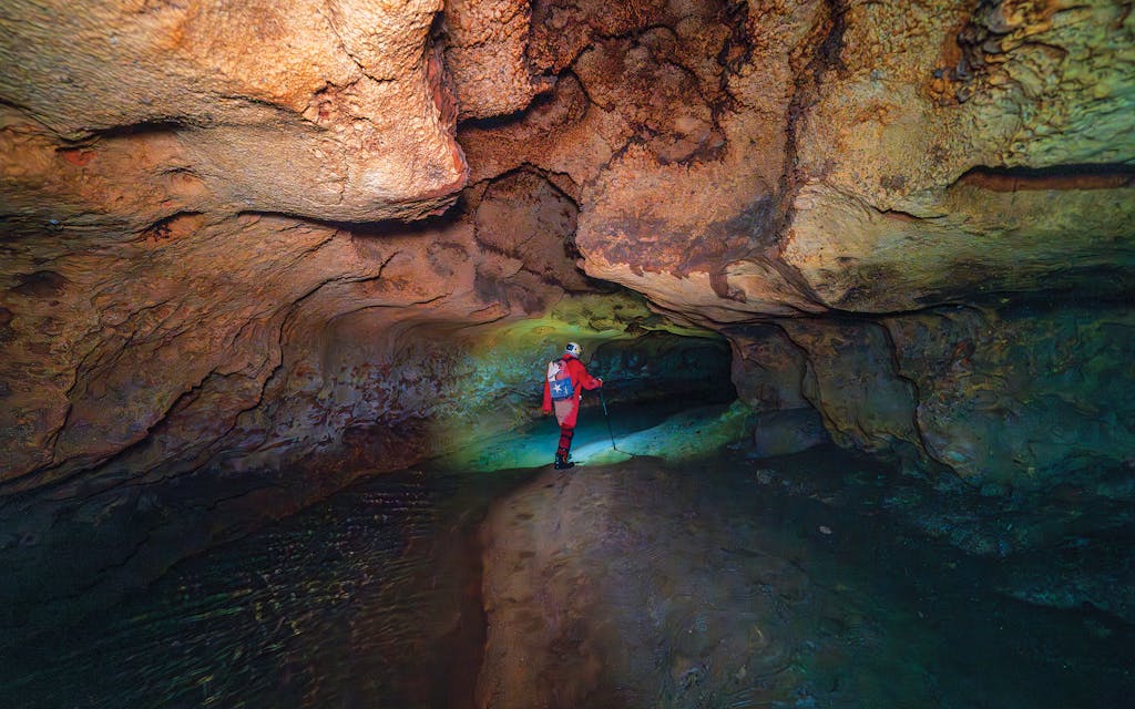 Kevin Pride, of the UT Grotto, slithering through a passage inside Honey Creek Cave, between Boerne and New Braunfels.