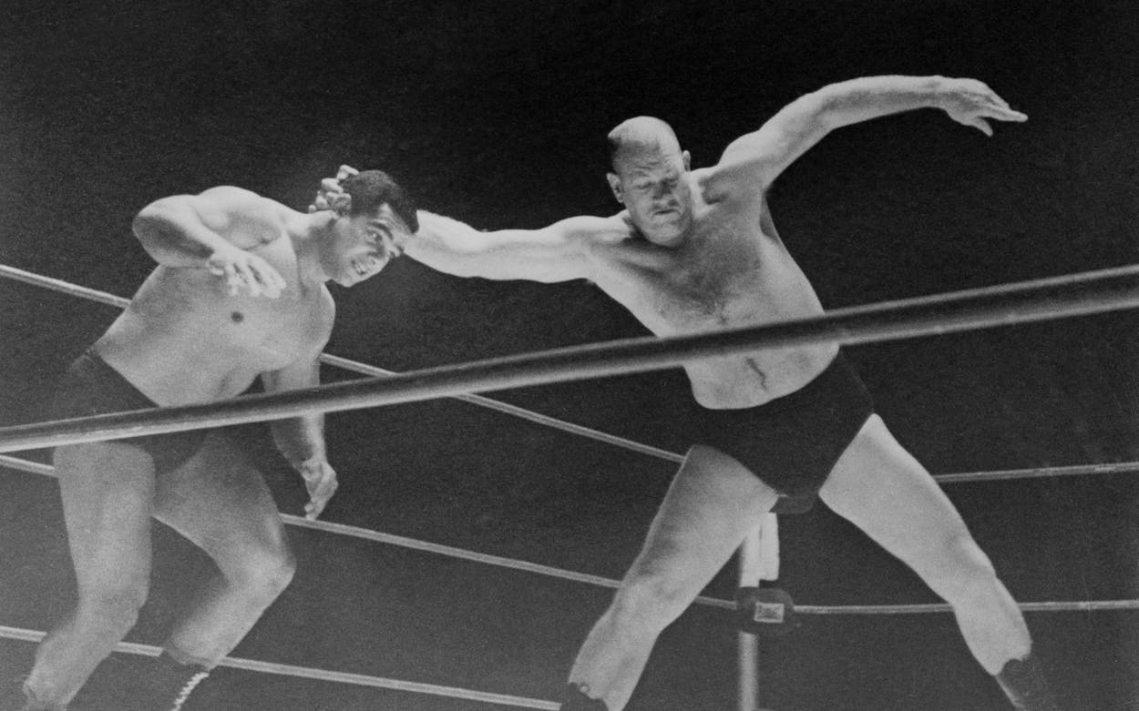 Fritz Von Erich prepares to throw Buddy Marino to the mat in their match.